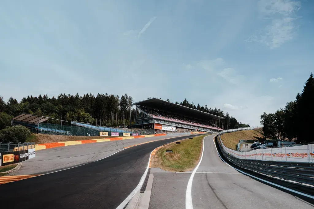 Die Steigung von Eau Rouge/Raidillon mit voll besetzter Haupttribüne im Hintergrund